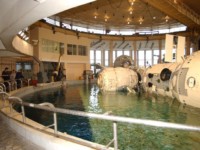 This picture shows the Hydrolab at Star City. The pool is about 12m deep, filled with warmed fresh water. The modules to the right are on a platform that rises and falls, allowing them to be raised out of the water for configuration and maintenance, and lowered into the water for EVA training. Cosmonauts use this facility to practice their moves during space walks, since hanging suspended in the water is similar to weightlessness in some ways. An EVA can last up to seven hours at a stretch, so the training dives are for the same length of time.